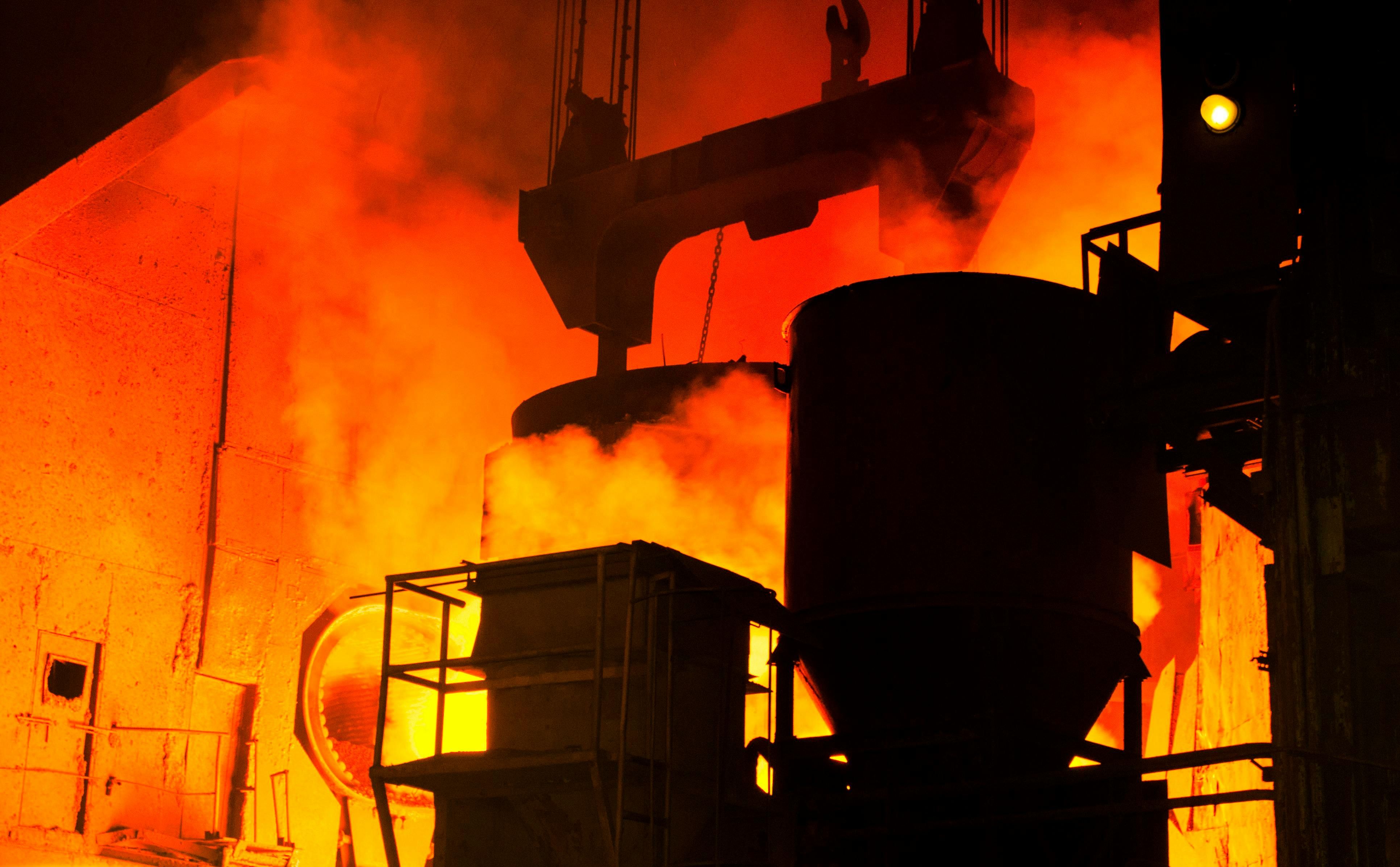 Coulée d'acier liquide en aciérie lors du transfert du four à arc électrique vers la poche métallurgique, avec dégagement de vapeur et lueur incandescente caractéristique de la fusion de ferrailles recyclées à environ 1 600 °C. Image libre de droit provenant de pexels.com